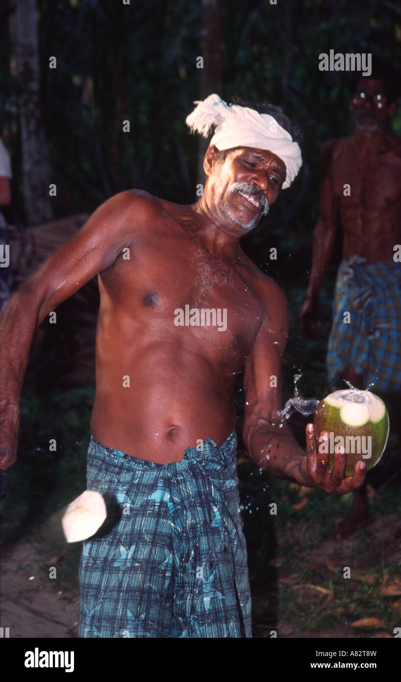 India Kerala indian man cutting a coconut in the backwaters Stock Photo