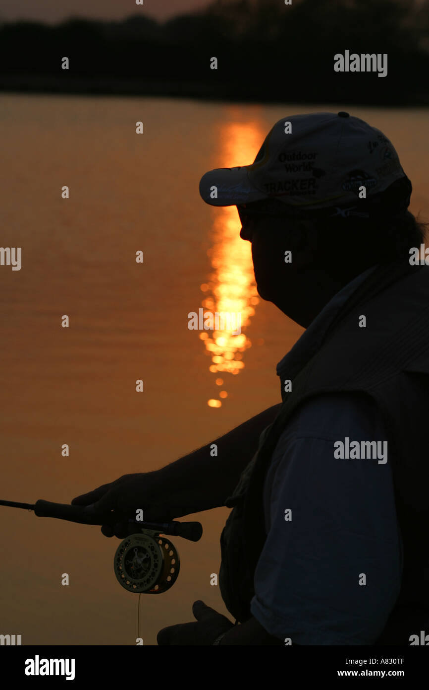 Silhouette fisherman at sunset Stock Photo - Alamy