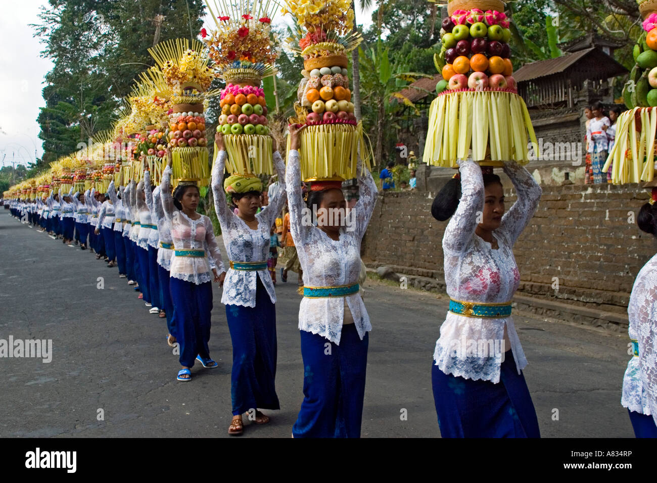 A seemingly endless precession of women, with a fruit offering, line up to enter a temple in Bali, Indonesia. Stock Photo