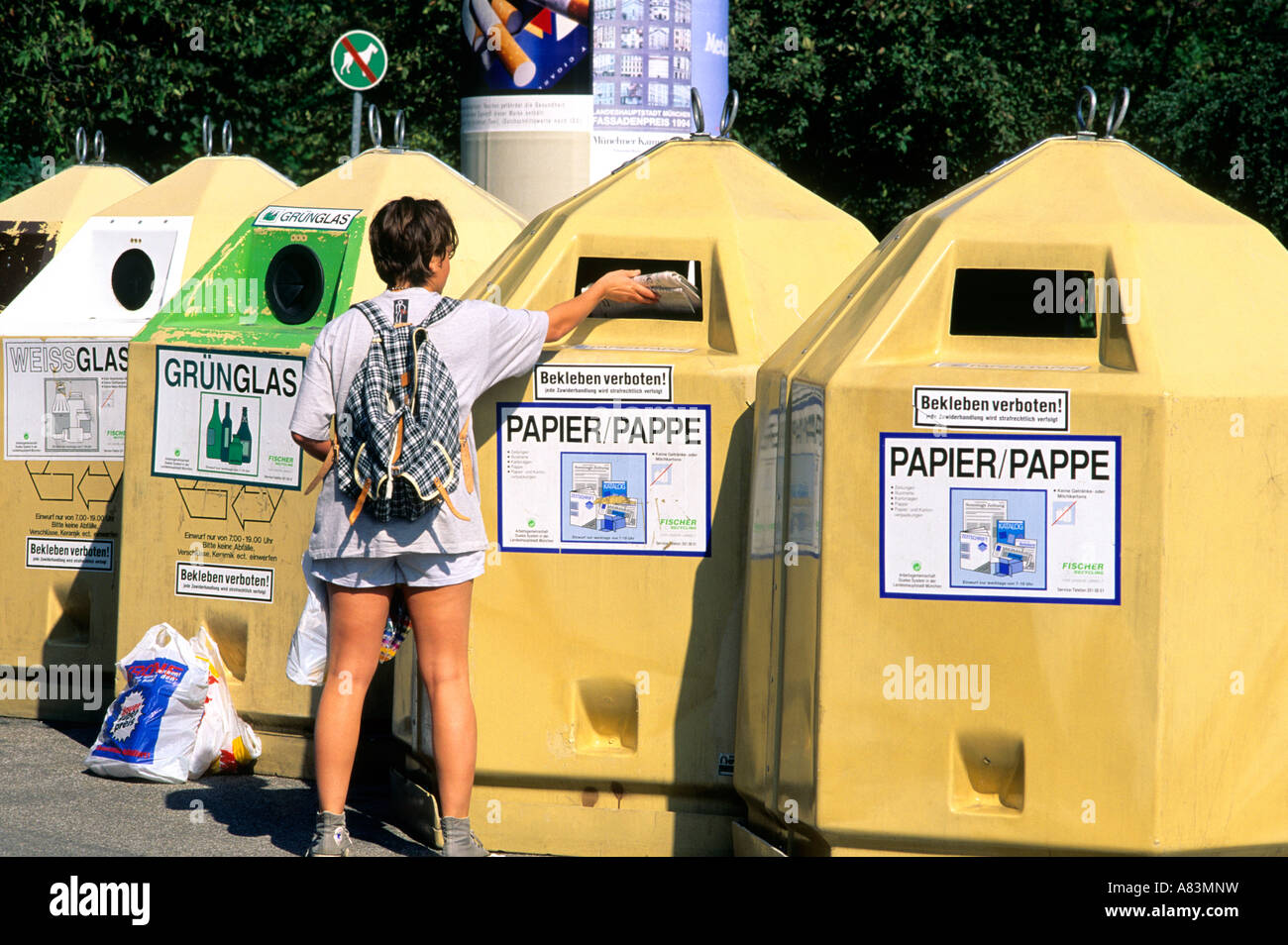 A woman depositing newspaper in recycling bins in Munich Germany Stock ...