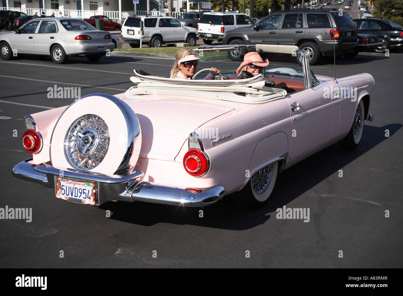 two ladies sitting in pink original 1956 ford thunderbird t-bird convertible. del mar, california, usa Stock Photo