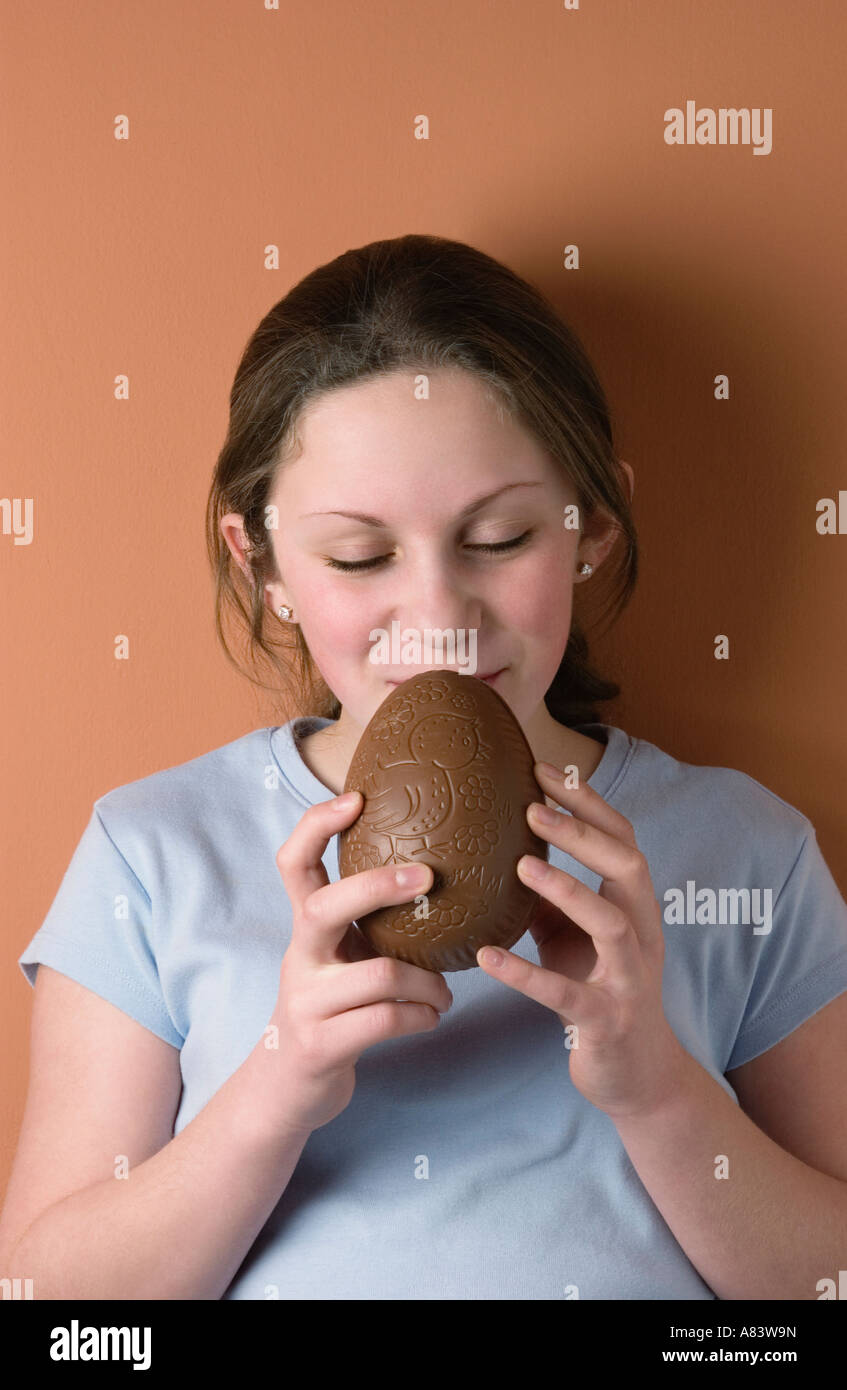 Girl eating milk chocolate egg Stock Photo