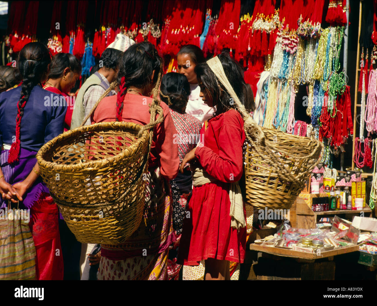 Kathmandu, Nepal; young women carrying baskets at stall selling beads and decorations. Stock Photo