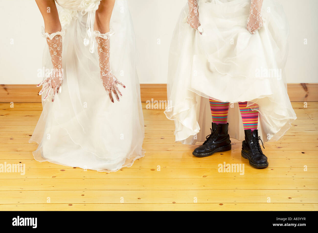 Bride lifting her dress to reveal boots and stripy socks underneath. Stock Photo