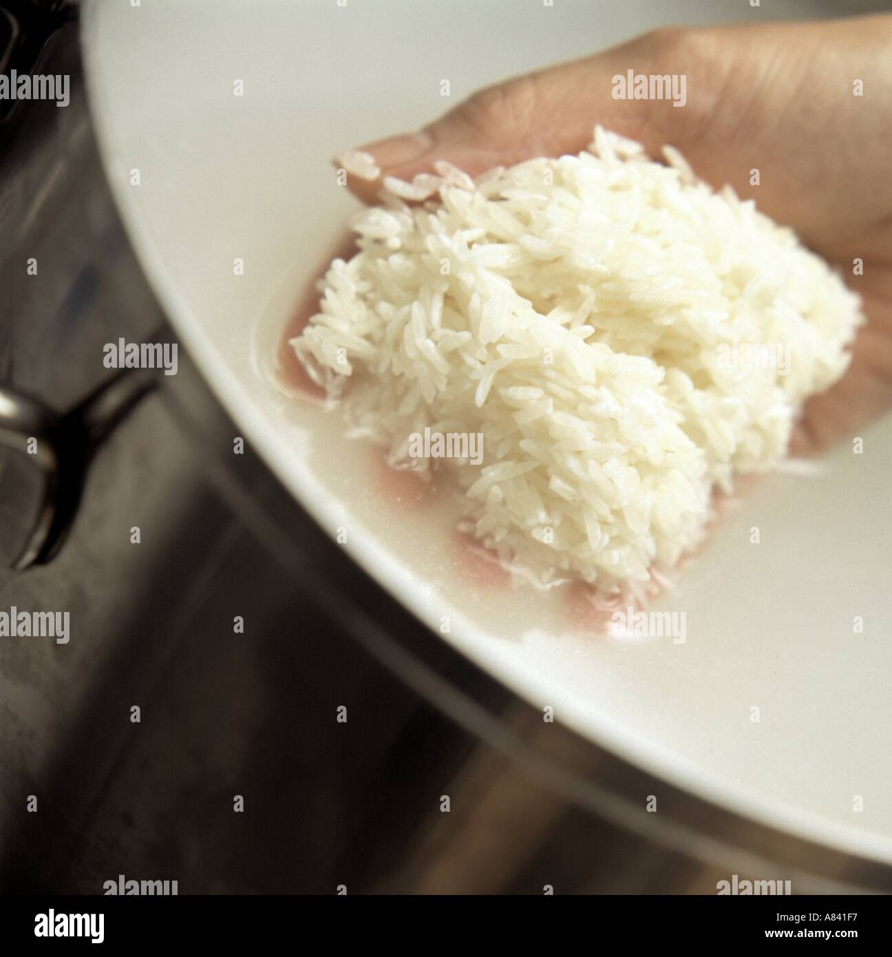 A Handful of Rice Being Rinsed Stock Photo Alamy