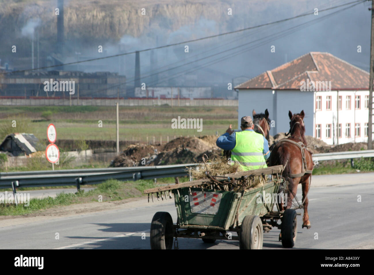 horse drawn wagon and the lead factory Sometra Copsa Mica is the most polluted town in Europe April 2007 Romania Stock Photo