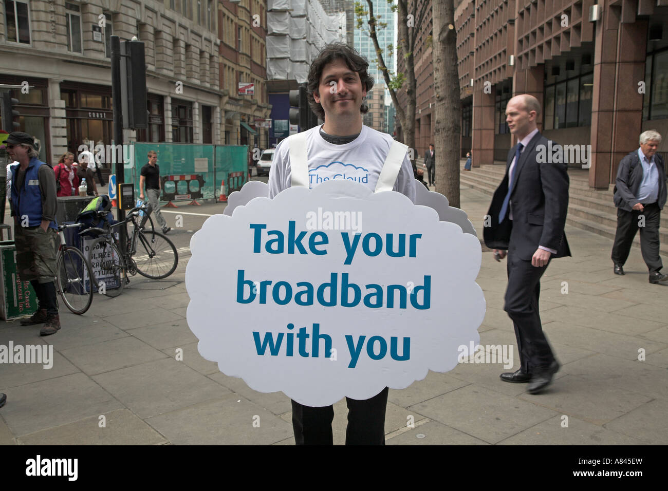 Smiling man holding advertising sandwich board for Cloud broadband internet, London, England Stock Photo