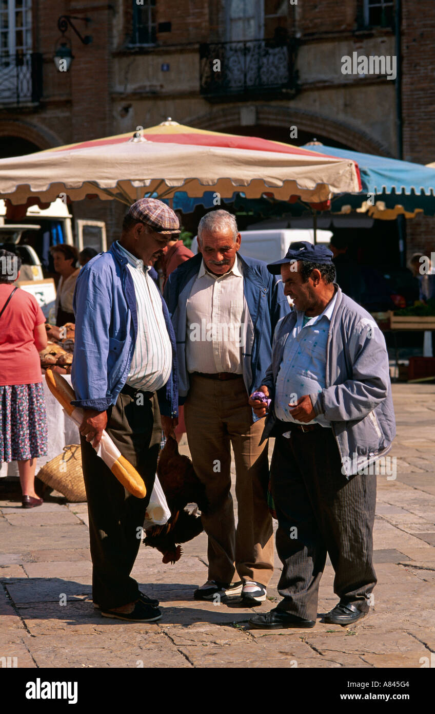 France, Southwest. Moissac.  North African men always meet to talk on market day, Saturday. Stock Photo