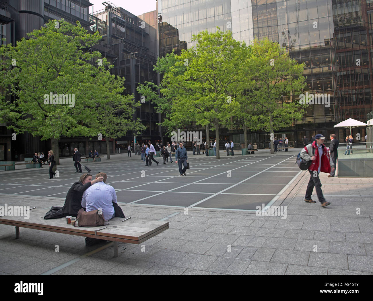 Young couple on bench  modern offices, Broadgate Circus, City of London, England Stock Photo