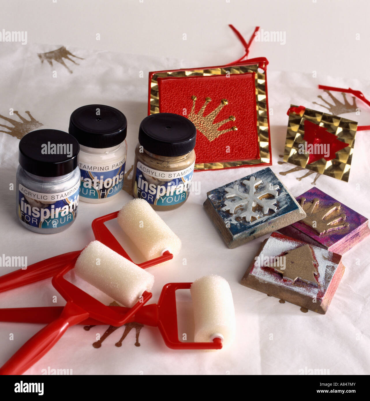 Close-up of small pots of paint with rollers and craft stamps with Christmas motifs Stock Photo