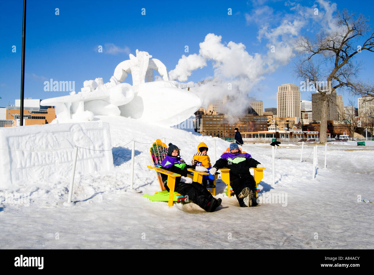 Family sitting by Margaritaville Snow Sculpture in Adirondack chairs ...