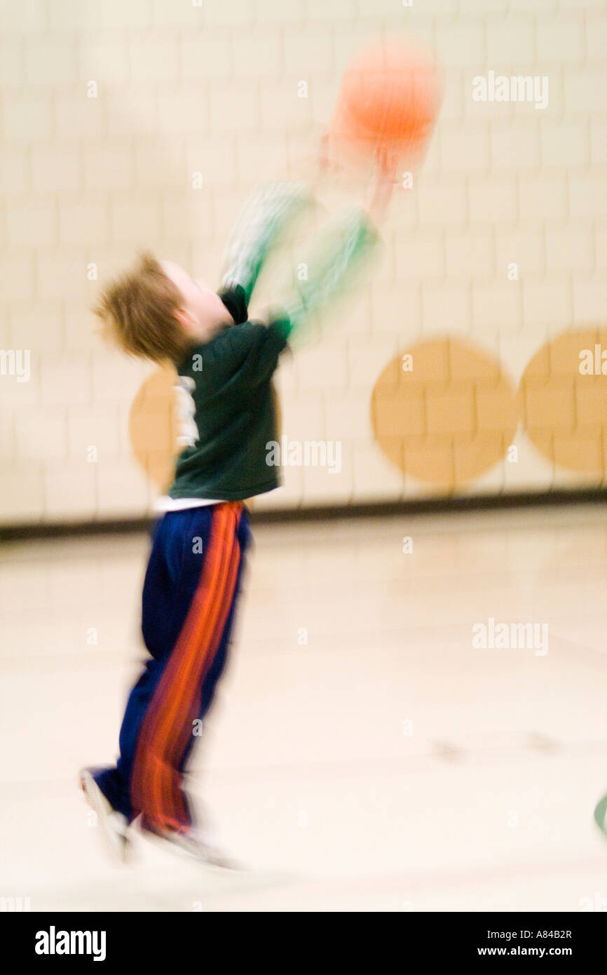 Blur of boy age 7 shooting a basket. Horace Mann Elementary School St Paul Minnesota USA Stock Photo