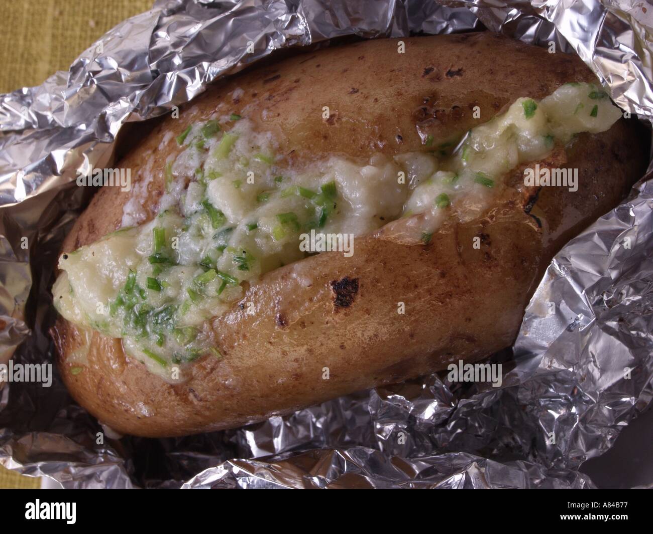 Baked potato with herb cream cheese Stock Photo
