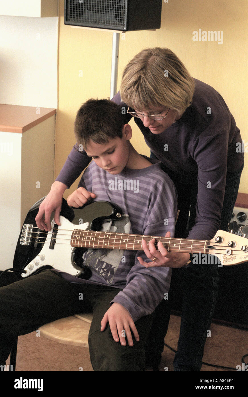 Sweden Örebro Teacher shows a boy how to play bass during a lesson ...