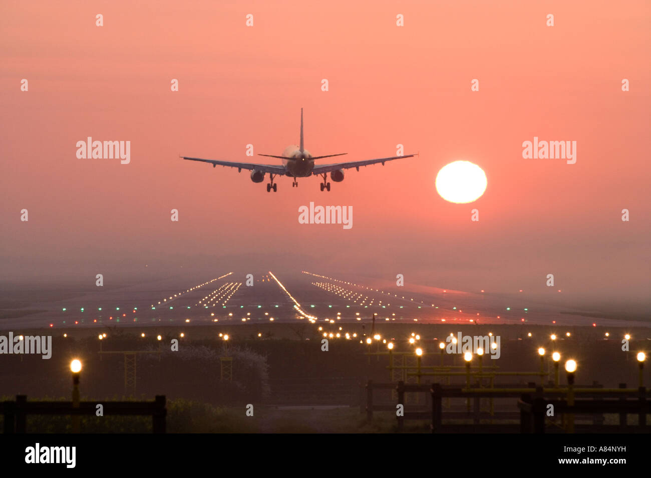Aeroplane landing at sunrise. Stock Photo
