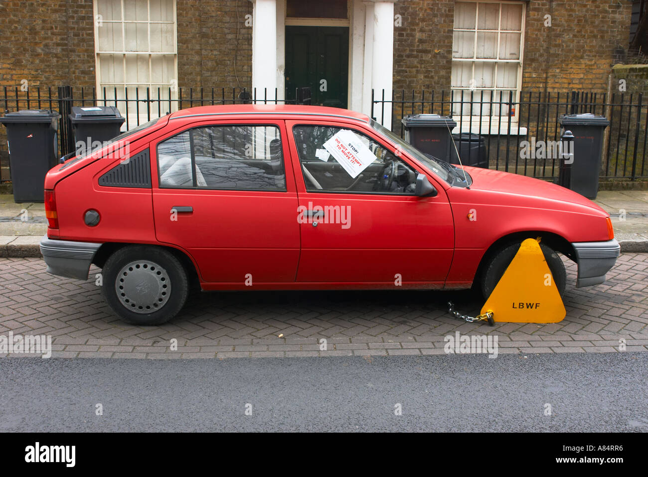 Red Vauxhall Astra clamped in a Walthamstow residential street Stock Photo
