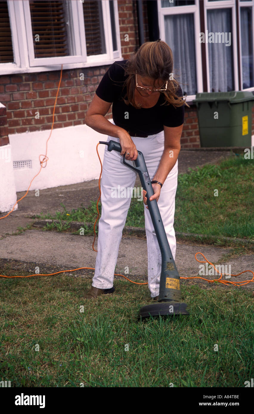 woman strimming the lawn Stock Photo