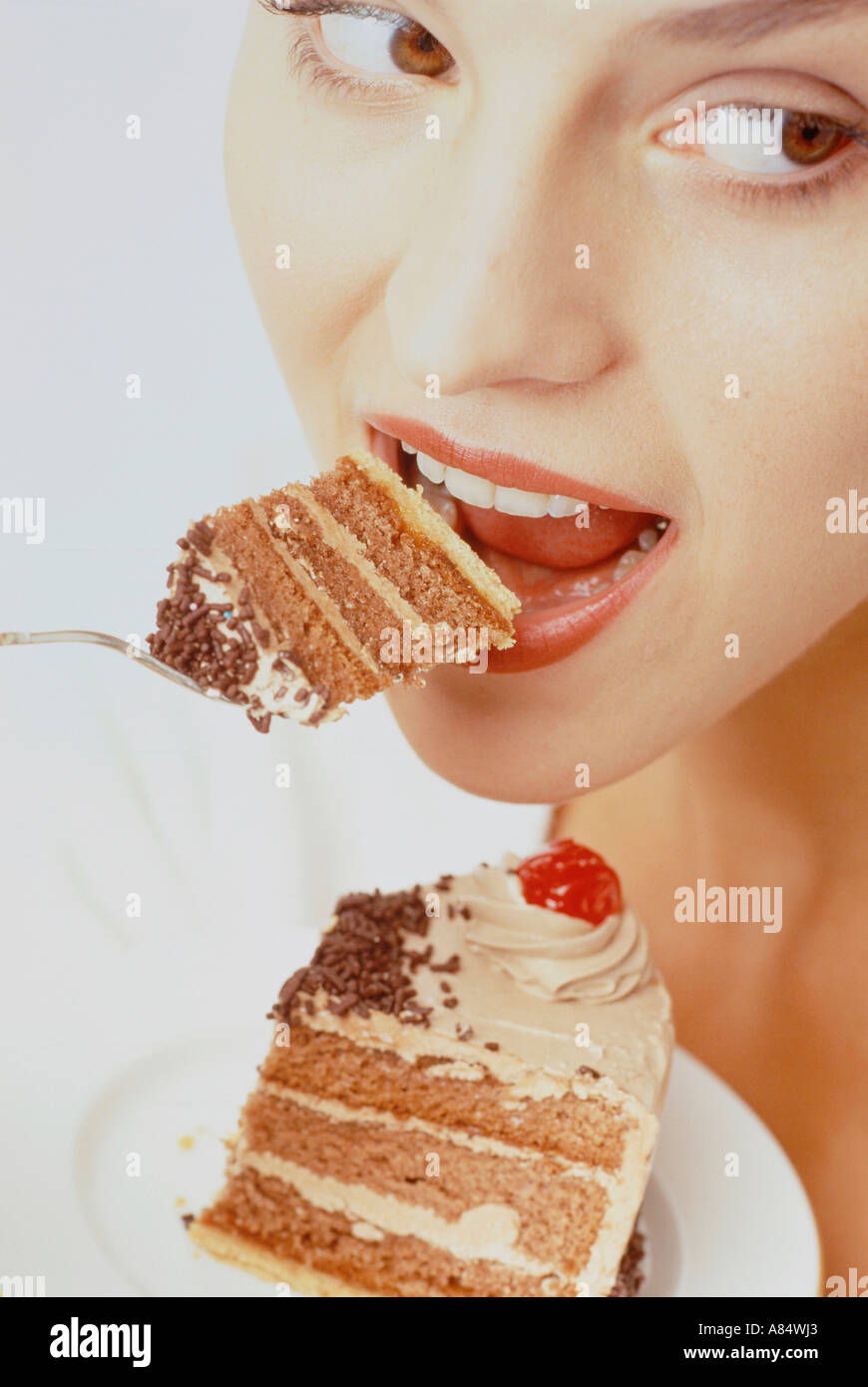 Close-up of young woman eating cake. Stock Photo