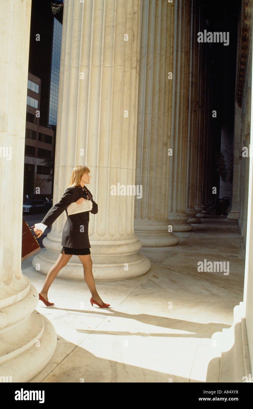 Professional woman striding into imposing building Stock Photo - Alamy