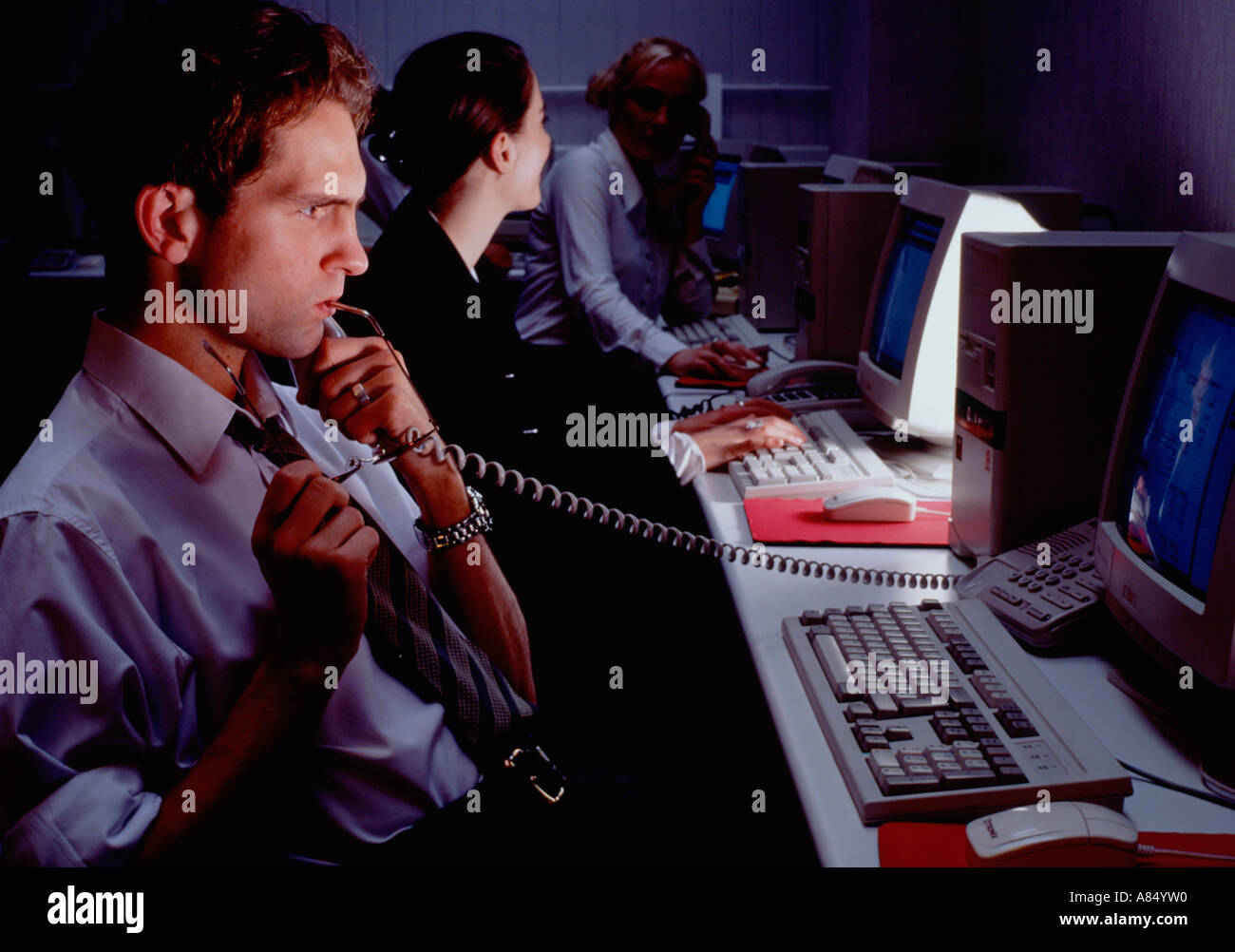 Call centre telephone operators with computer monitor screens at night Stock Photo Alamy
