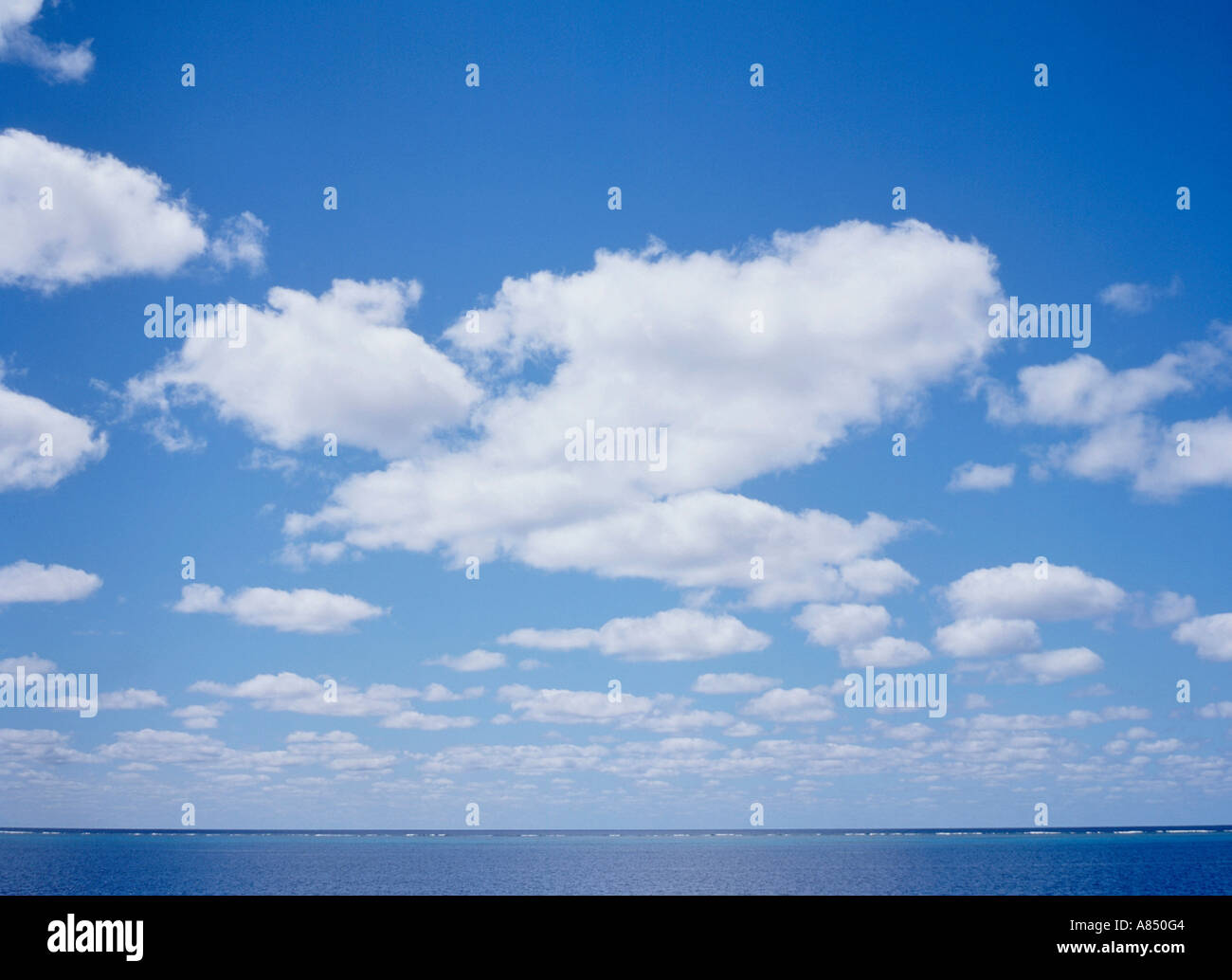 View of blue sky with white cumulus clouds over the ocean horizon.  Great Barrier Reef. Queensland. Australia. Stock Photo