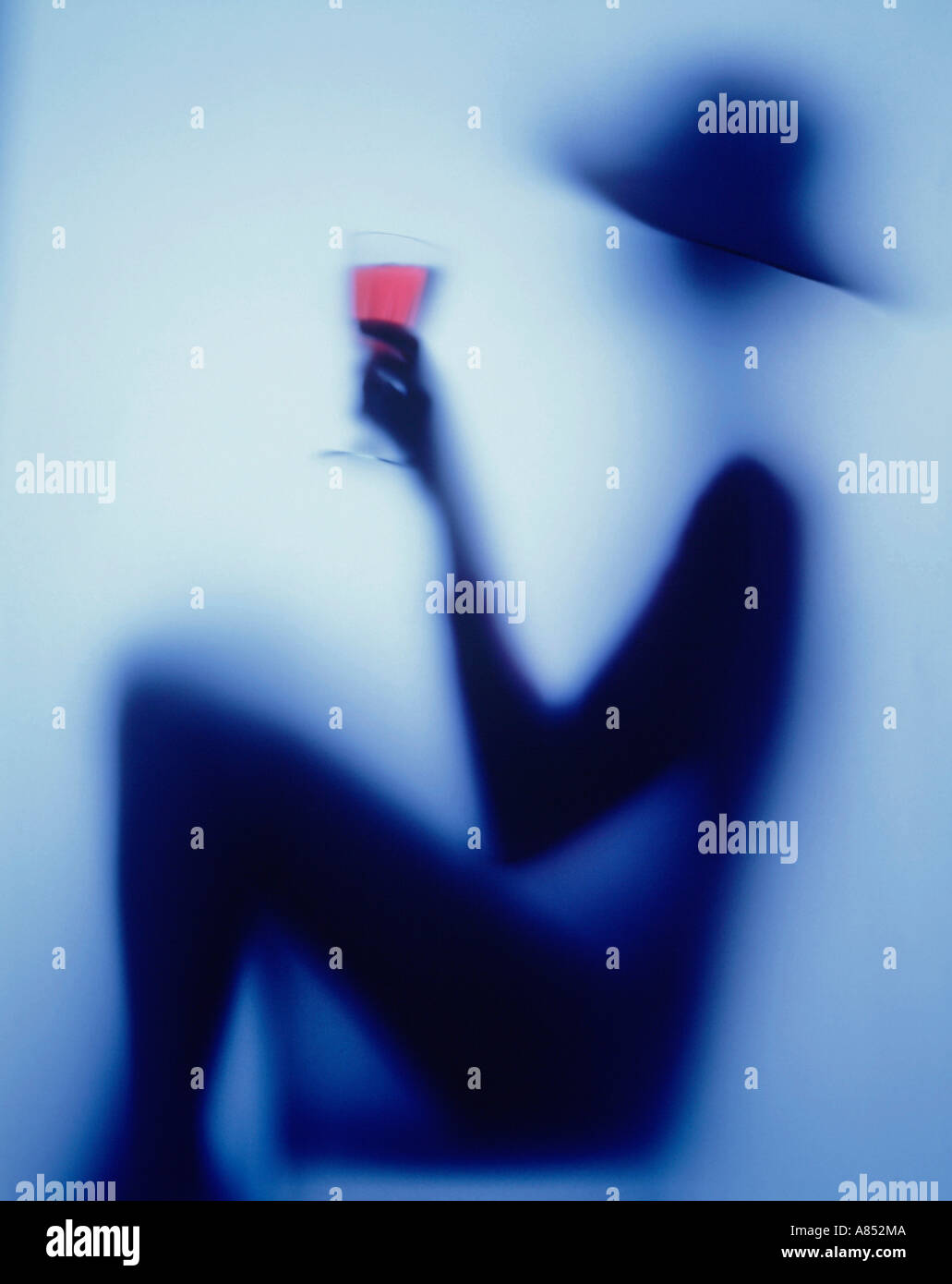 Impressionist fine art photographic image of a silhouette of a woman with a glass of wine. Stock Photo
