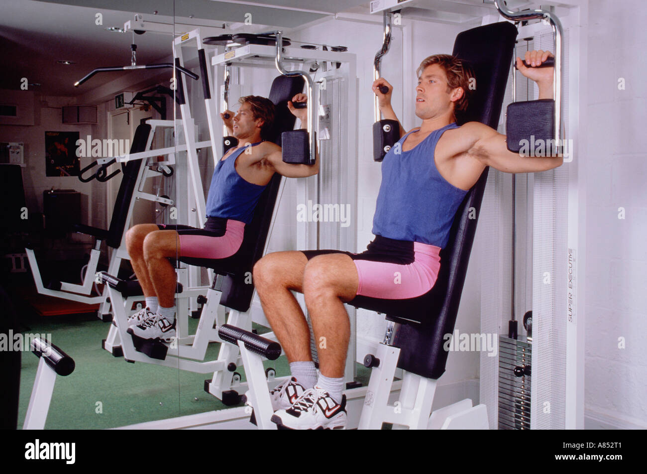 Young man exercising using gymnasium equipment Stock Photo Alamy