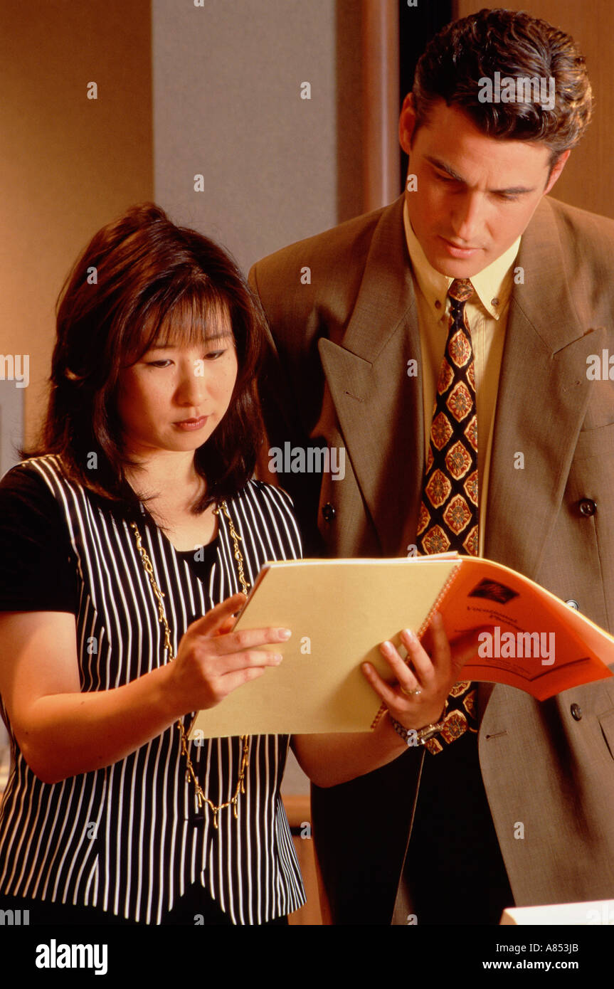 Man and woman studying document in office. Stock Photo