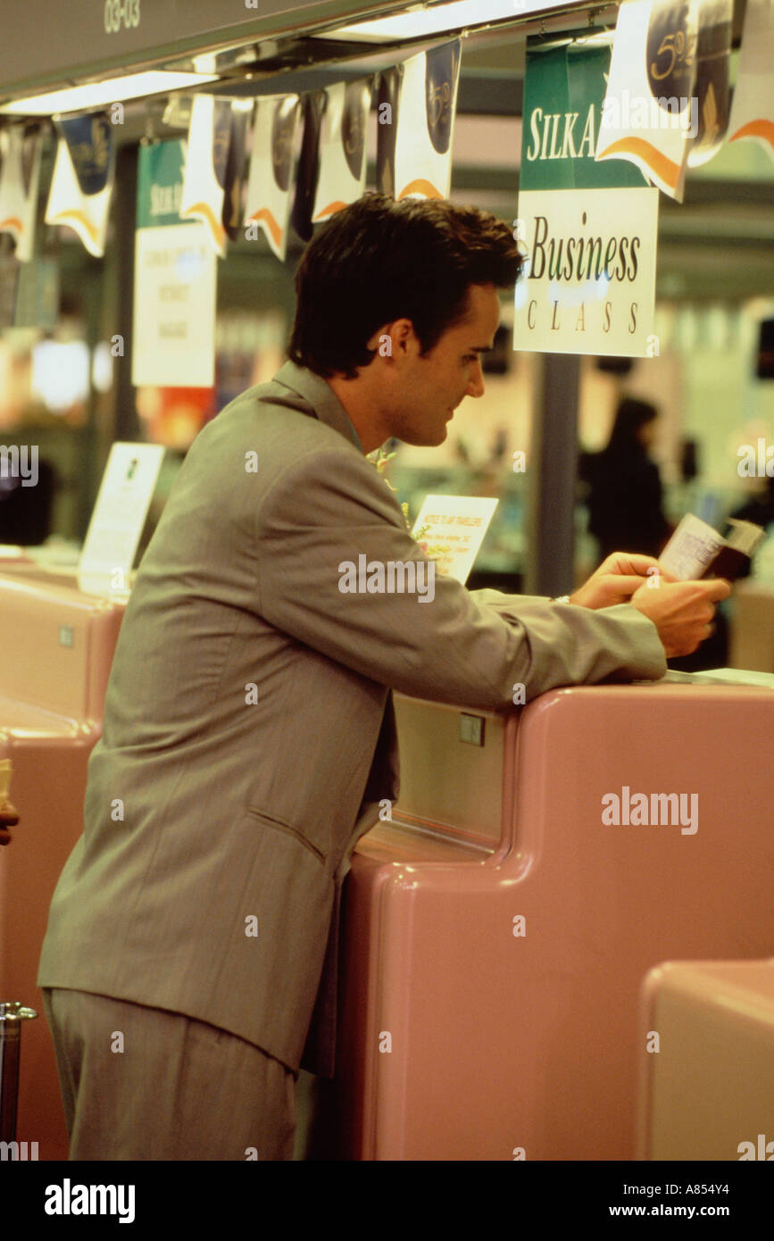 BYoung man executive at airline check in desk . Stock Photo