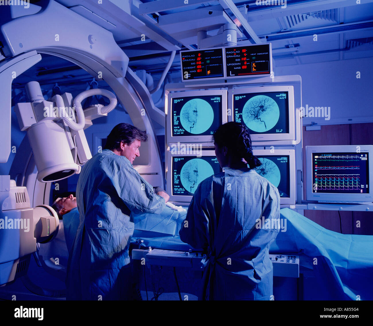 Surgeon and nurse with patient in hospital Angiography scanning room. Stock Photo