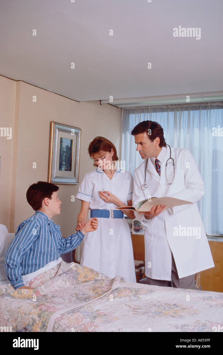 Doctor and nurse with young boy patient in hospital. Stock Photo