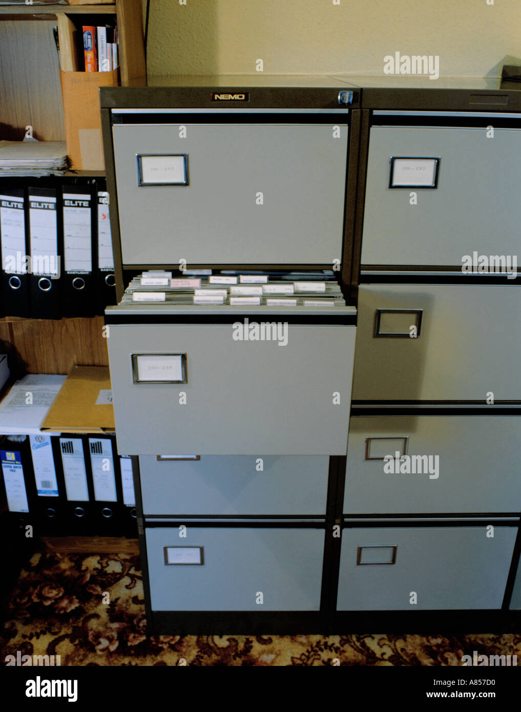 Steel filing cabinet with open drawer, showing files and folders. Stock Photo