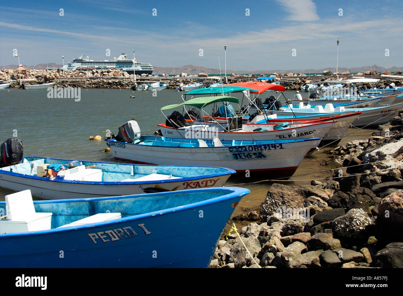 Colorful fishing boats with a cruise ship at the Baja Sur port of Loreto Mexico Stock Photo