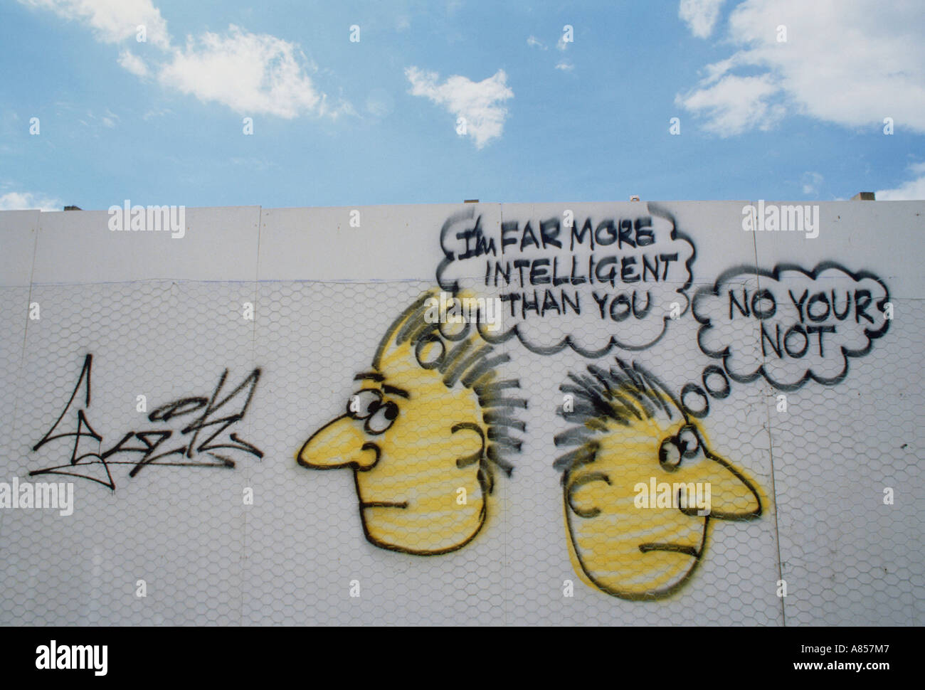 Artwork. Graffiti message painted on wall. Comical cartoon 'Intelligence'. Stock Photo