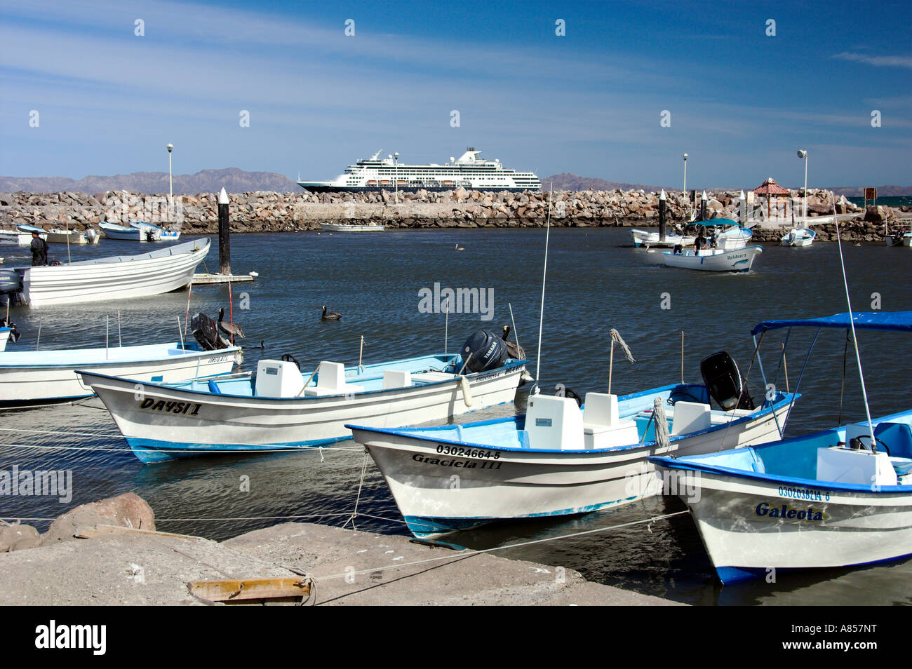 Colorful fishing boats and a cruise ship at the Baja Sur port of Loreto Mexico Stock Photo