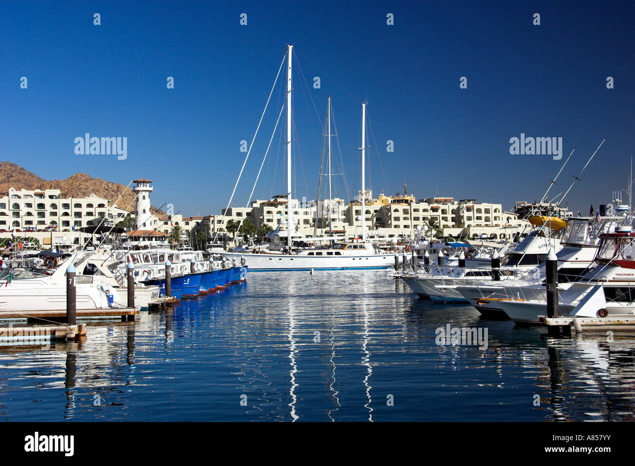 The marina with pleasure boats and a lighthouse at the resort of Cabo San Lucas Mexico Stock Photo
