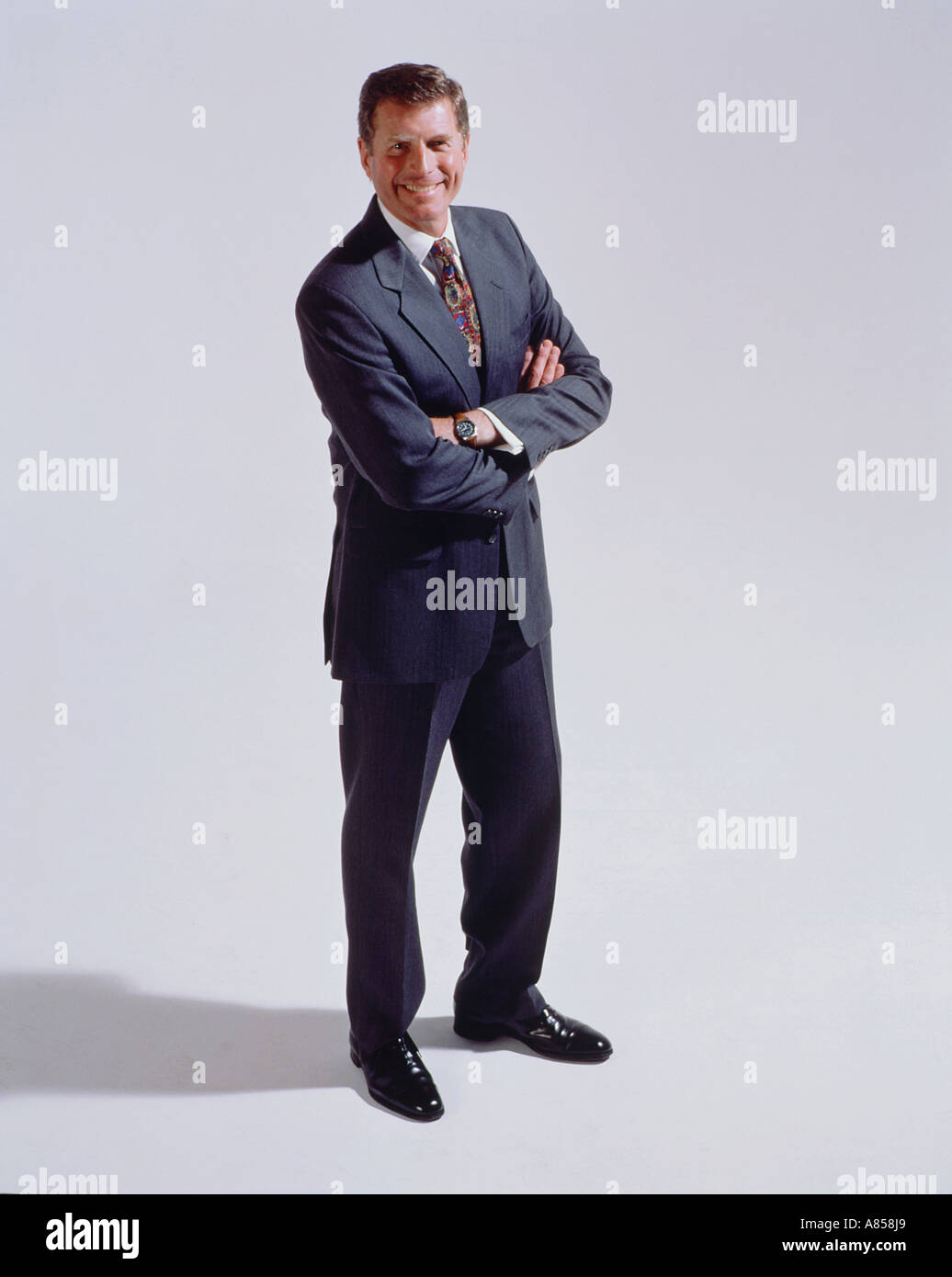 Middle aged man with arms folded standing in studio. Stock Photo