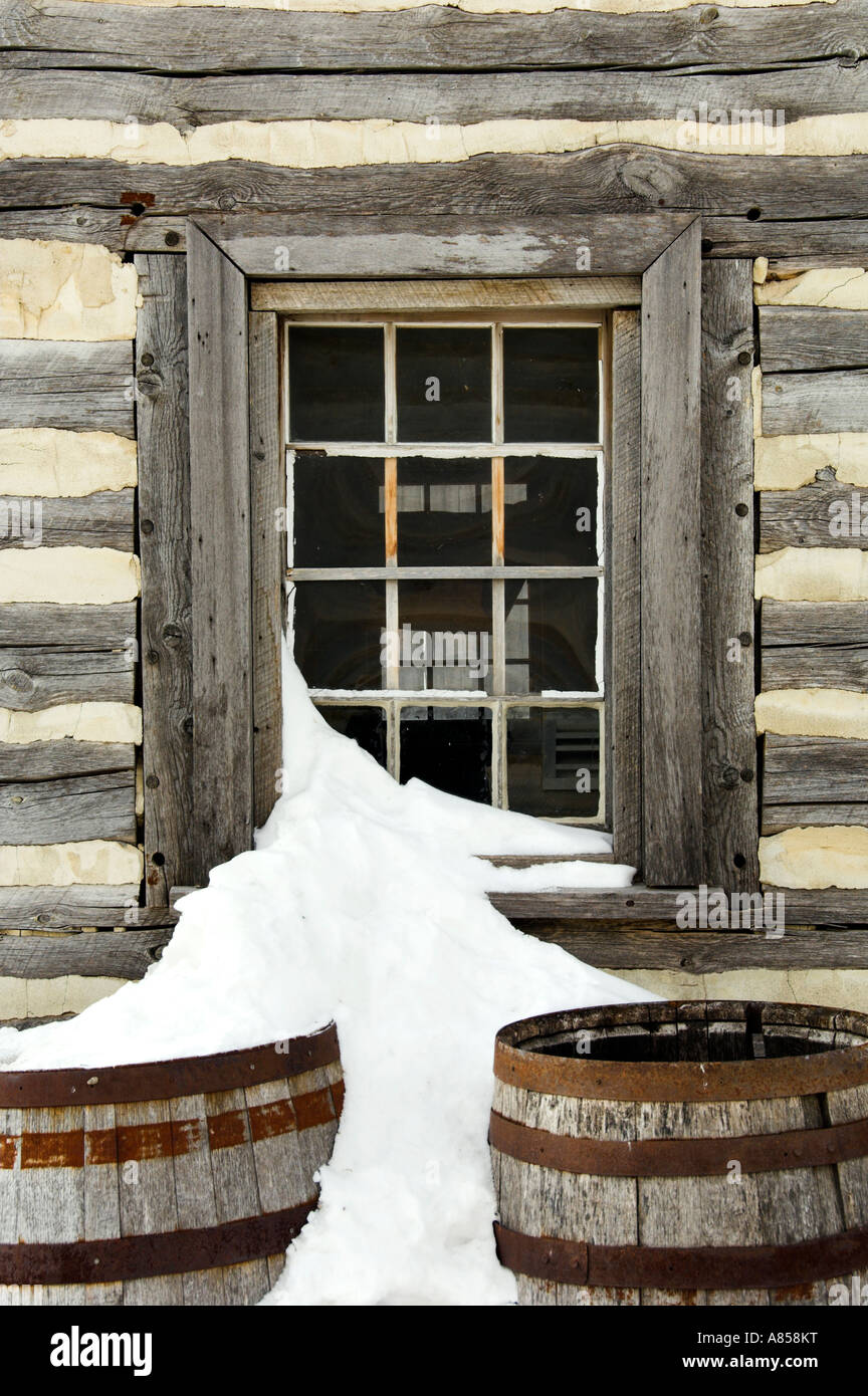 A cottage window with snow and old rain barrels inside Fort Gibralter
