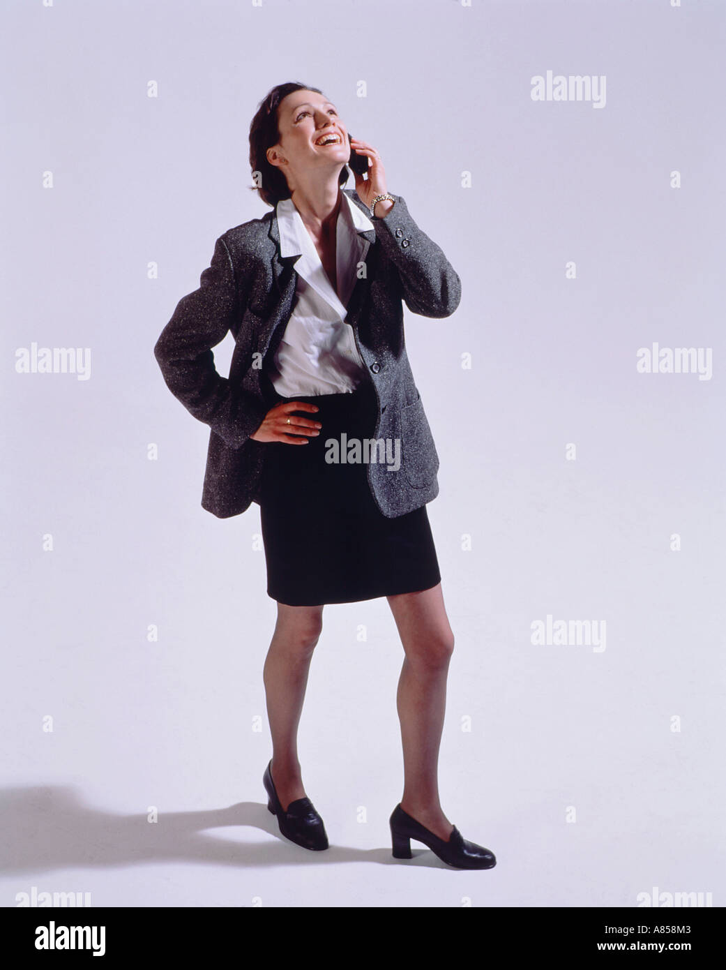 Studio image of young woman talking on mobile 'phone. Stock Photo