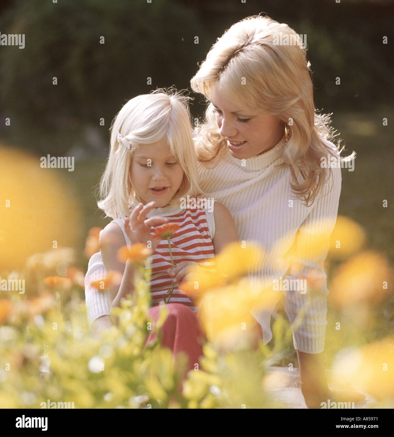 mother and daughter in flower garden Stock Photo