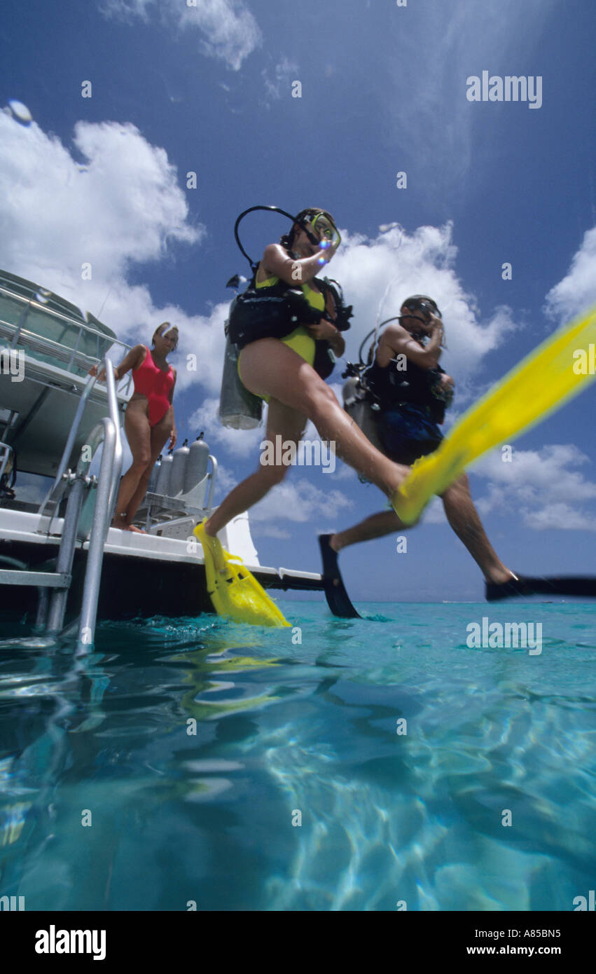 Divers doing giant stride entry off dive boat Providenciales Provo