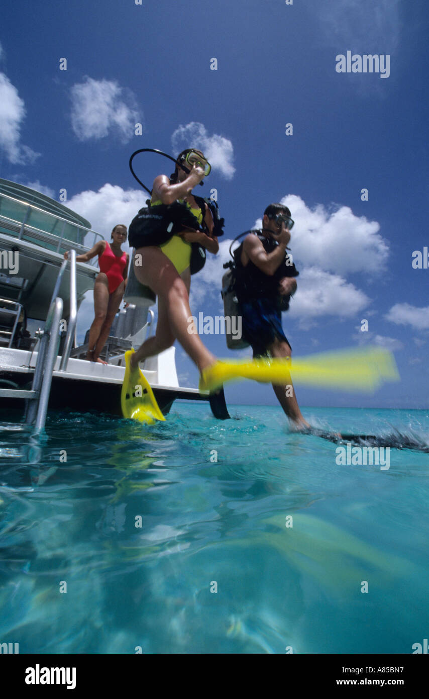 Divers doing giant stride entry off dive boat Providenciales Provo