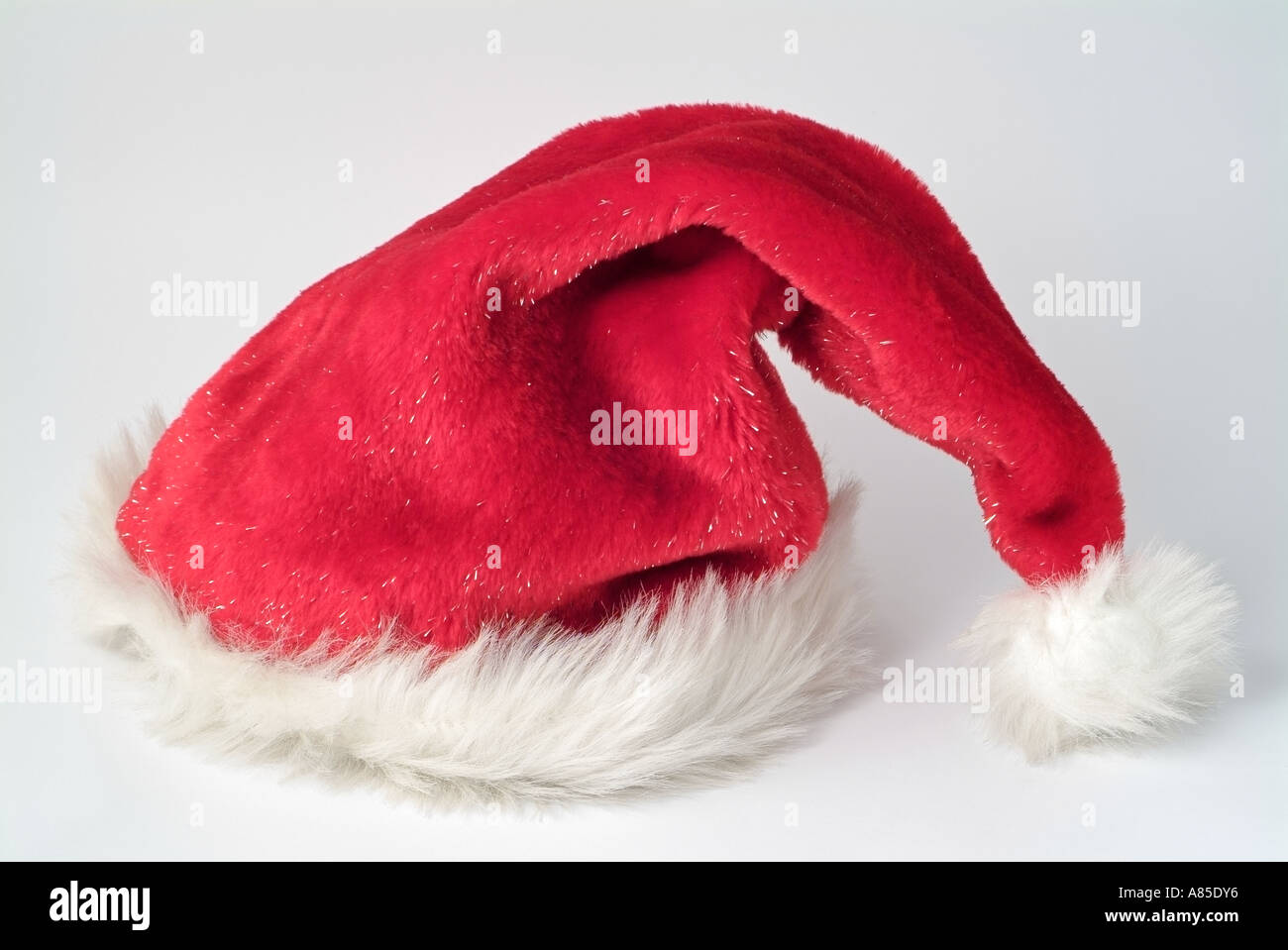 Red Father Christmas Hat With White Fur Trim Against A White Background Stock Photo