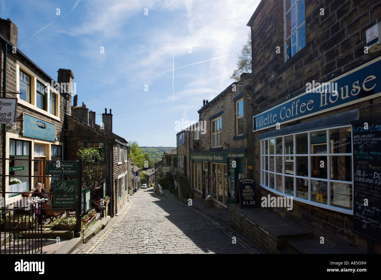 Shops and cafes on the main street in the village centre, Haworth, West Yorkshire, England, UK Stock Photo