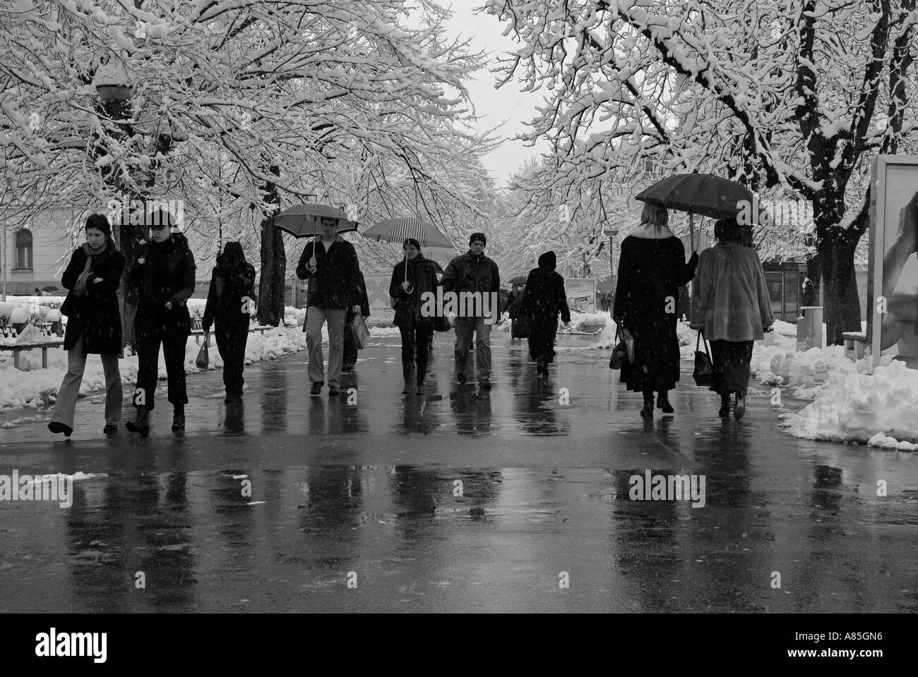 People Walking in a Busy European City Street During Winter Snow Stock Photo