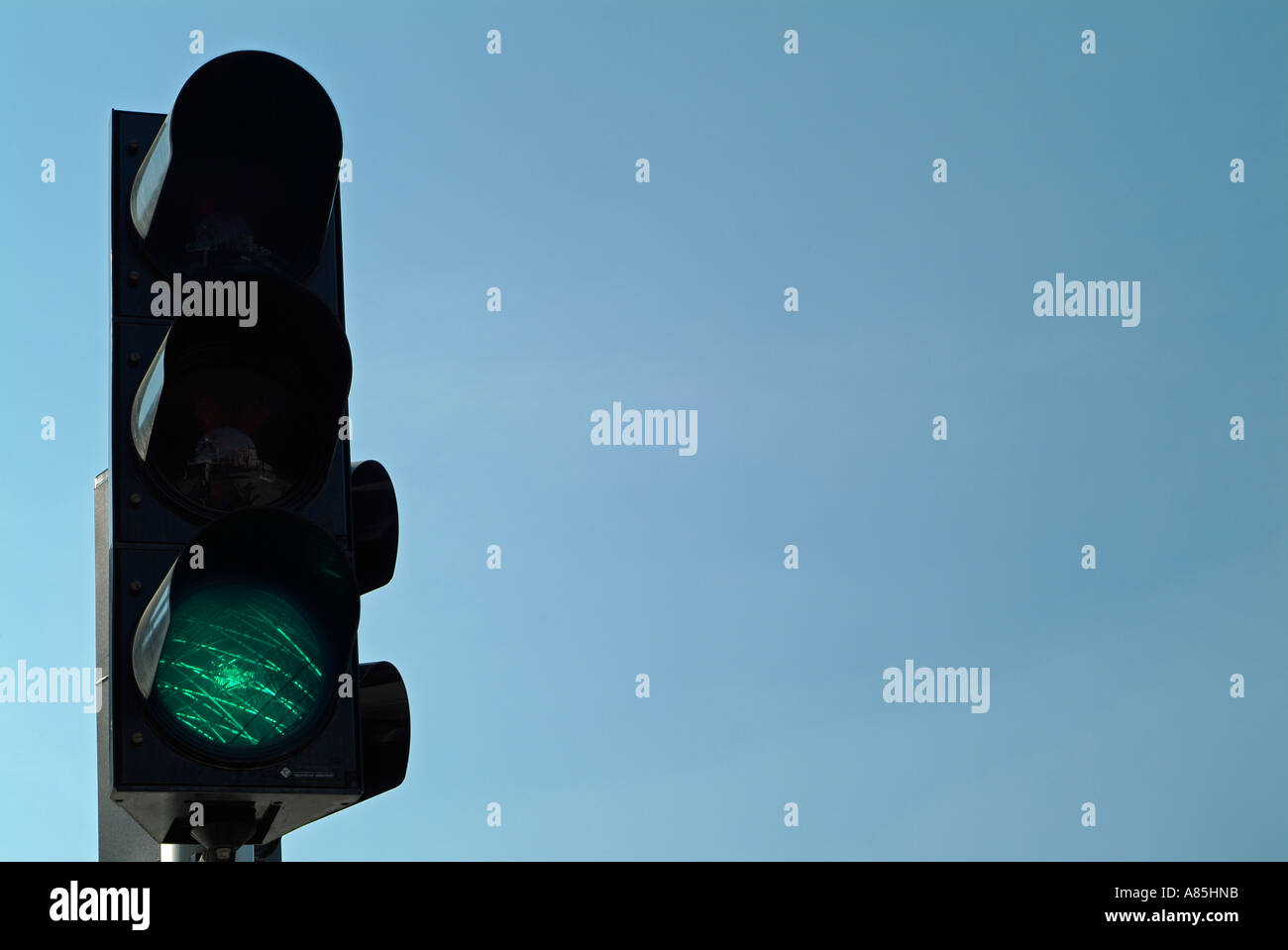 Green Traffic Light Against a Blue Sky Stock Photo