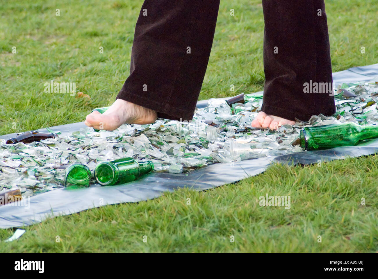 Walking with bare feet on broken glass at charity fund raising event