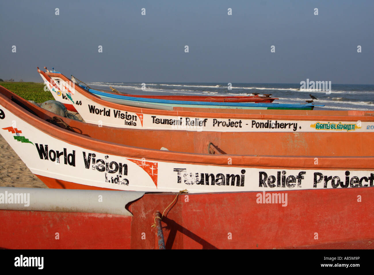 Boats donated by World Vision India, after the tsunami of 26th December 2004, stand on a beach in Puducherry, India. Stock Photo