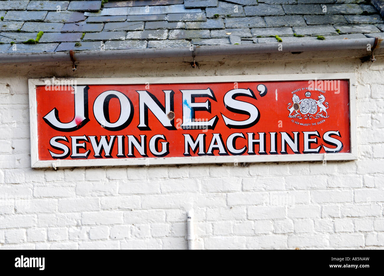 Old enamel JONES SEWING MACHINES sign with royal warrant in Montgomery Powys Mid Wales UK Stock Photo