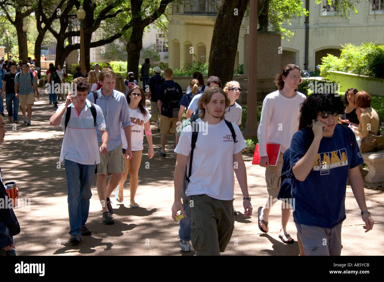 Students walking and using cell phones on the campus of University of Texas in Austin Stock